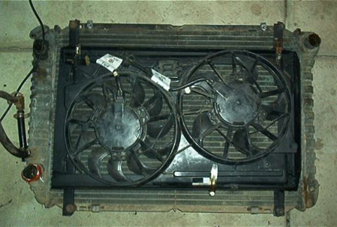 1986 Ford Bronco - Radiator assembly with dual electric fans, wires connected, and visible mounting brackets.