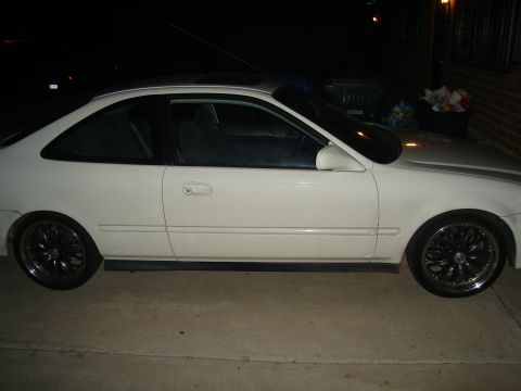 1997 Ford Probe - A white coupe is parked on a concrete surface at night, showing its side profile and custom wheels.