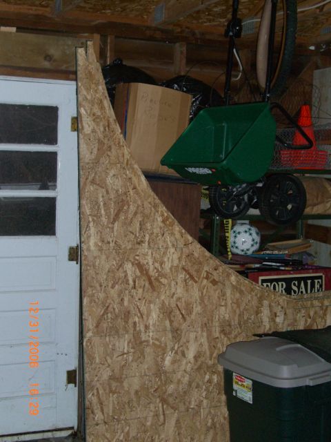 1993 Ford Probe - A cluttered garage space features a DIY ramp, storage shelves, and a wheelbarrow.