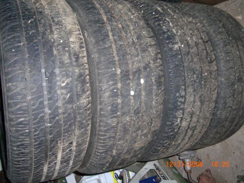 1993 Ford Probe - Four used tires are stacked together, likely for sale or storage.