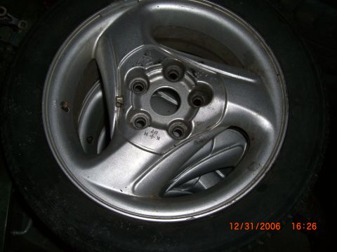 1993 Ford Probe - Close-up of a silver alloy car wheel, possibly for a Ford Probe, with visible markings.