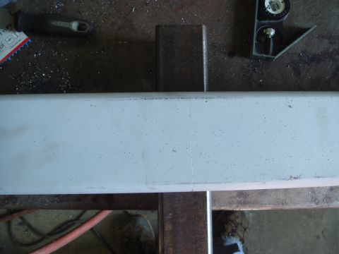 1996 Ford Bronco - A metal bar is being worked on in a workshop, with tools and a level visible.