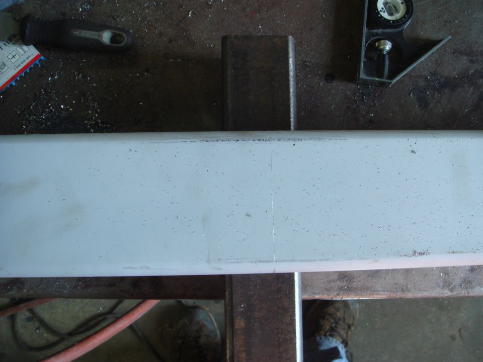 metal bar being worked on, possibly for a bumper, with tools and a level nearby