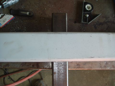 1996 Ford Bronco - A metal bumper part is shown on a workbench with various tools and a red air hose.