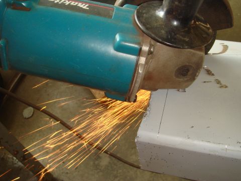 1996 Ford Bronco - Metal is being cut with an angle grinder, creating a shower of sparks.