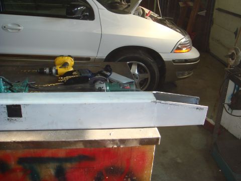 1996 Ford Bronco - A metal beam is in the foreground, with tools and a white van in the background.