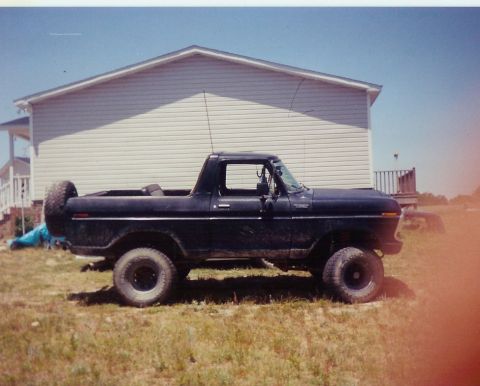 1978 Ford Bronco - A black 1978 Ford Bronco is parked on a grassy lawn with a house in the background.