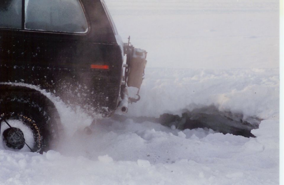 1978 Ford Bronco rear wheel spinning in deep snow, throwing snow spray