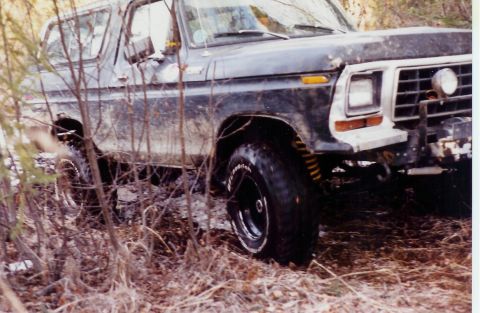 1978 Ford Bronco - Muddy 1978 Ford Bronco off-road, showing front quarter and tire detail.