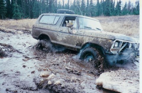 1978 Ford Bronco - Muddy 1978 Ford Bronco struggling through deep mud off-road.