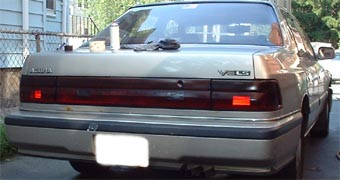 1997 Ford Crown Victoria - Rear view of a tan Acura Vigor sedan parked in a driveway.