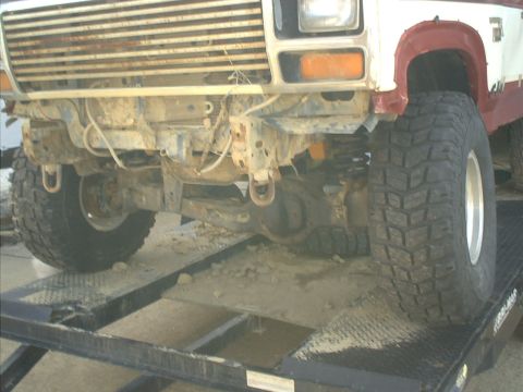 1986 Ford Bronco - This lifted truck features aggressive off-road tires and a prominent, weathered grille, suggesting it is built for terrain.