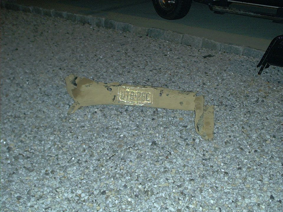 rusted metal part with license plate reading UTR-25C on gravel