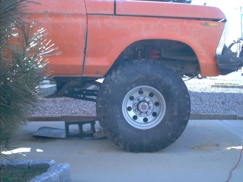 1978 Ford Bronco - This orange 1978 Ford Bronco features a lifted suspension and oversized tires, suggesting off-road modifications.