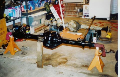 1978 Ford Bronco - Vehicle axles are set up on jack stands in a garage setting.