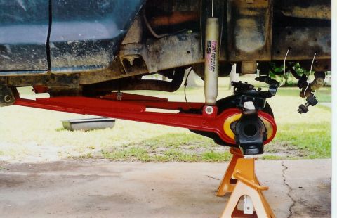 1978 Ford Bronco - Close-up of a modified front axle assembly, likely for an off-road vehicle, on jack stands.