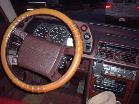 1997 Ford Crown Victoria - The dashboard and steering wheel of an Acura are shown, with a van visible through the windshield.