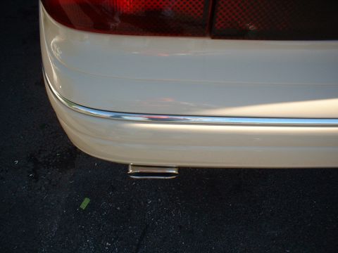 1996 Mercury Grand Marquis - Rear view of a 1996 Mercury Grand Marquis, a chrome accent strip on the bumper and an oblong exhaust tip.