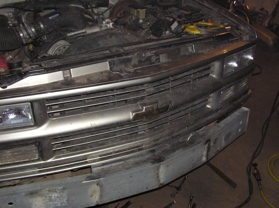 Front grille and engine bay of a 1995 Chevrolet pickup truck with the hood open