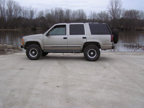 2000 Chevrolet Tahoe - This silver SUV, likely a 1995 model, is shown from the side with a spare tire mounted on the rear.