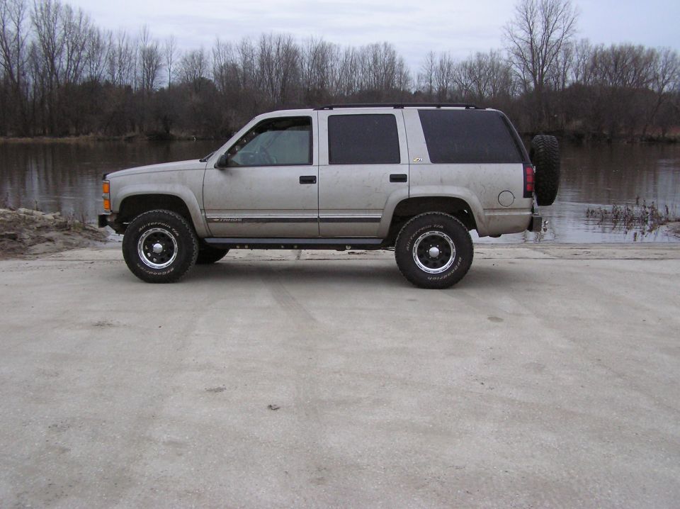 Silver SUV side view with spare tire on rear door. Appears to be a 1995 model