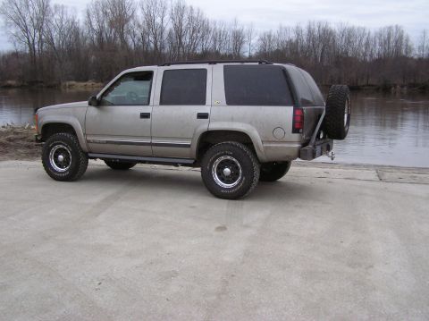 2000 Chevrolet Tahoe - This SUV is parked near a body of water with trees in the background.