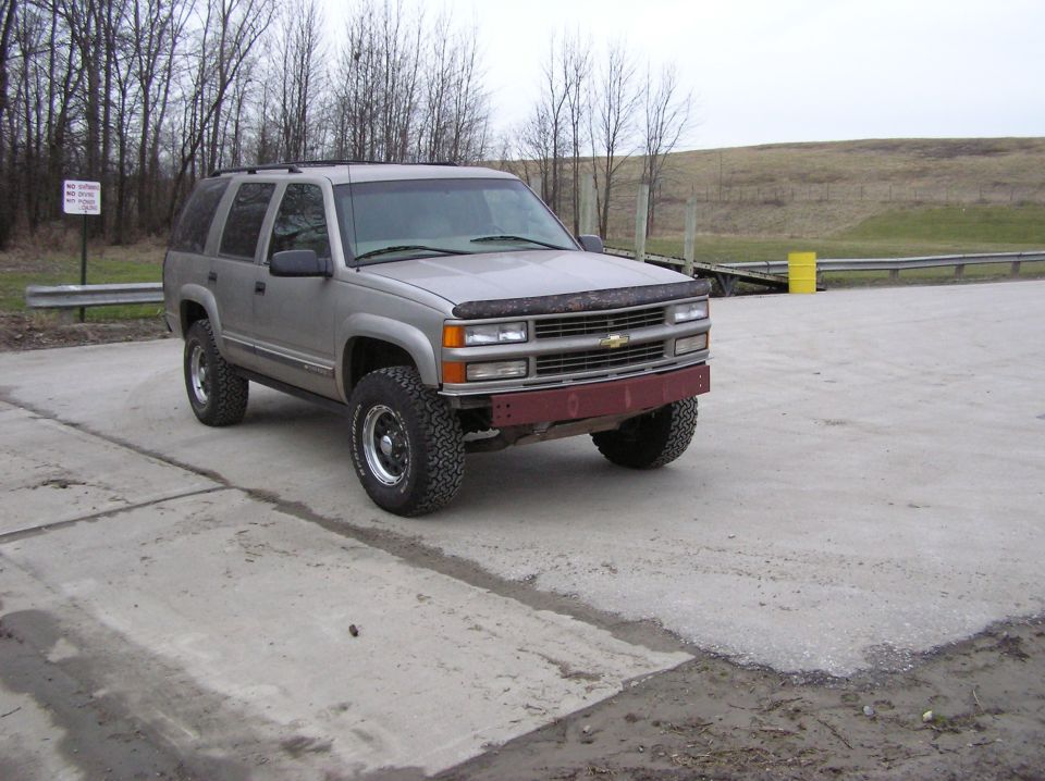 Silver 2000 Chevrolet Tahoe front view with aftermarket wheels and red bumper