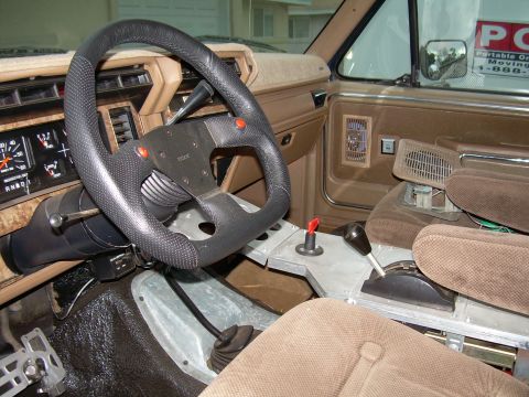 1986 Ford Bronco - Interior view of a 1986 Ford Bronco, an aftermarket steering wheel and console modifications.