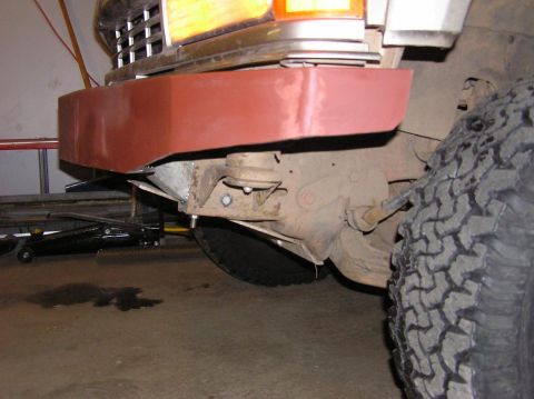 2000 Chevrolet Tahoe - A vehicle's front bumper is being worked on, showing suspension components and a large tire.