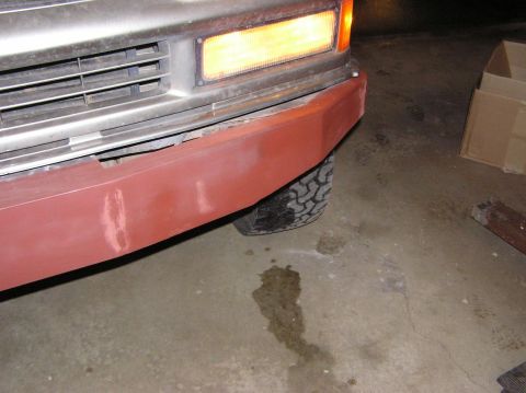 2000 Chevrolet Tahoe - A close-up view of a vehicle's front bumper and tire, showing signs of repair and wear.