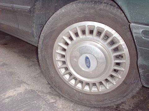 1997 Ford Crown Victoria - Side view of a 1997 Ford Crown Victoria's wheel and lower body panel.