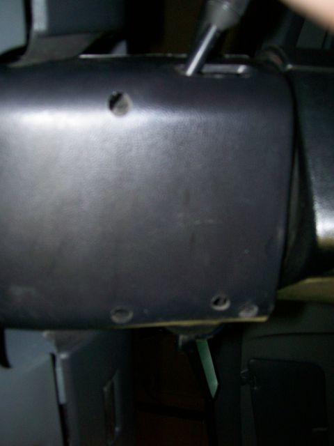 1992 Ford Bronco - Close-up of a vehicle's interior steering column shroud, showing screw holes and a lever.