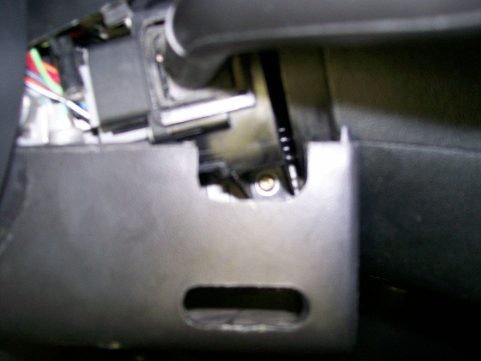 Under-dash close-up of a steering column with exposed wiring harness