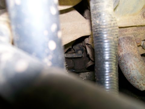 1992 Ford Bronco - A close-up view of various engine components, including hoses and metal brackets, within a vehicle.