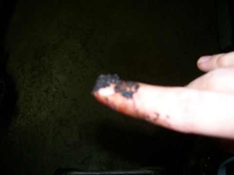 1992 Ford Bronco - A finger is covered in black residue, possibly from engine maintenance.