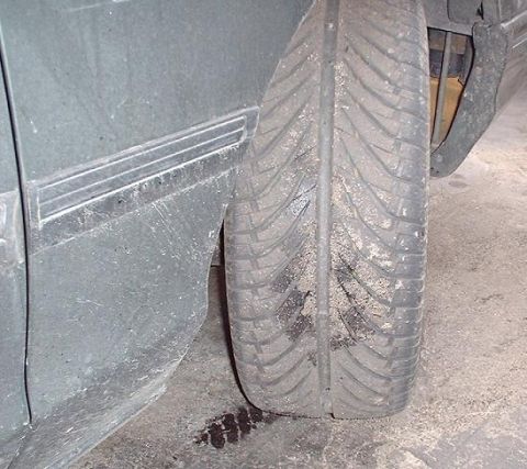 1997 Ford Crown Victoria - Close-up of a vehicle's side fender and tire, showing sand accumulation.
