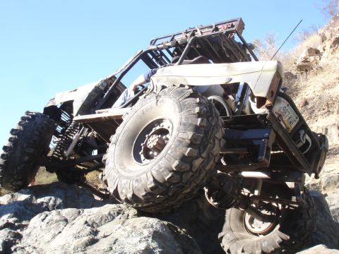 1984 Ford Bronco - Custom buggy navigating a rocky terrain with a clear blue sky overhead.