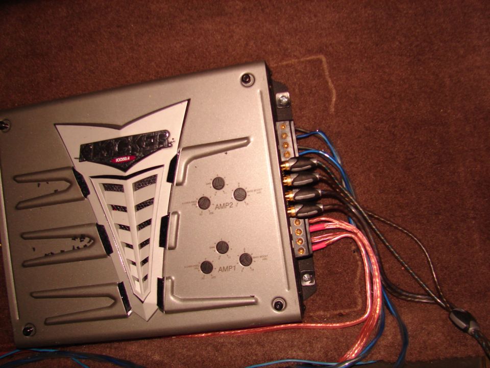 Silver car amplifier with Kicker logo and wiring