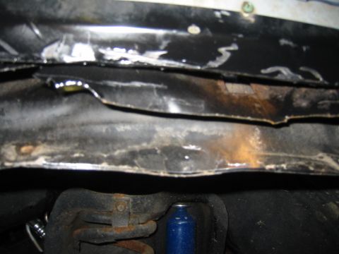 1986 Ford Bronco - Close-up of the underbody structure and suspension parts of a vehicle.