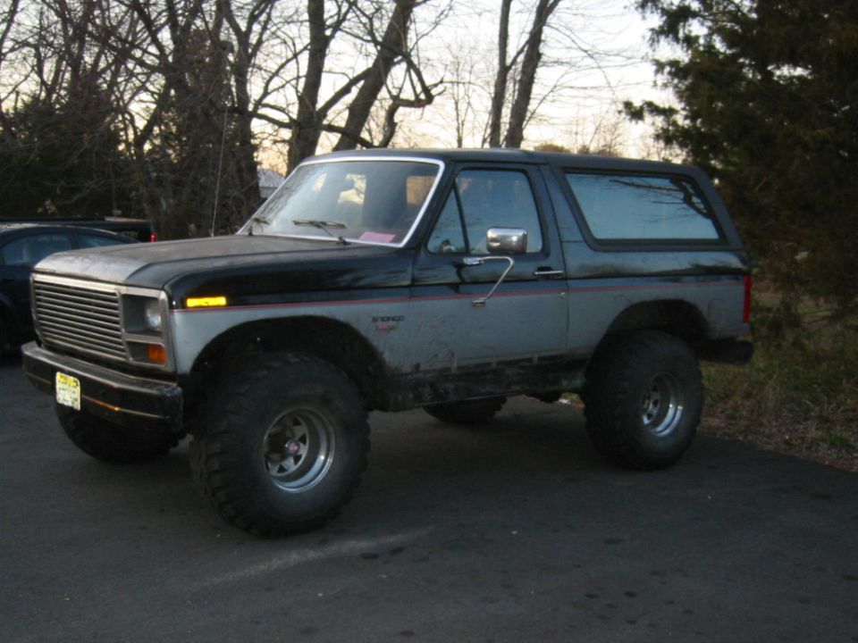 Black and grey SUV with large tires, 3/4 front view