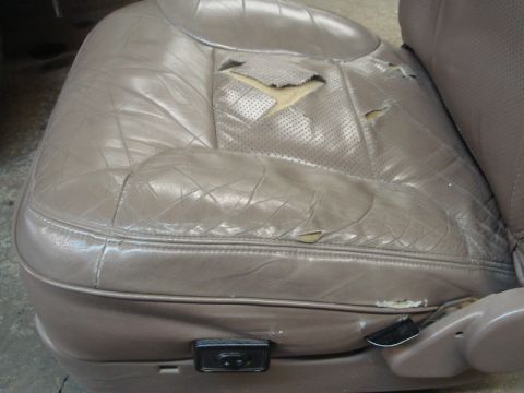 1996 Ford Bronco - Driver's seat interior shows significant wear and tear on the leather upholstery.