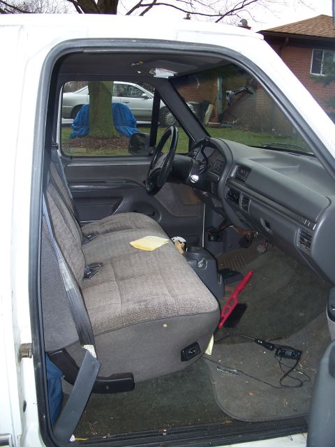1971 Ford Ranchero - The interior of a white pickup truck is visible, a bench seat and dashboard.