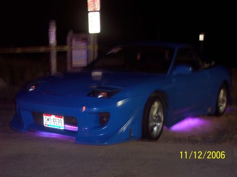 1995 Ford Probe - A blue 1995 Ford Probe is seen from the front at night, illuminated by purple underglow lights.