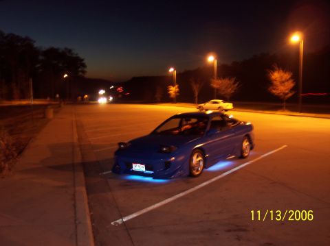 1995 Ford Probe - A blue 1995 Ford Probe is parked in a lot at night, illuminated by streetlights and its own underglow lighting.