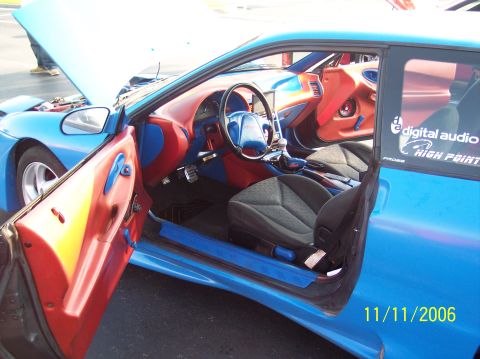 1995 Ford Probe - Customized 1995 Ford Probe interior features bright blue and red accents, aftermarket audio, and racing seats.