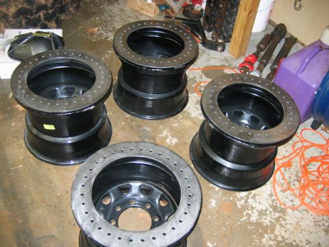 1992 Ford Mustang - Four black racing wheels are shown stacked on a concrete floor in a garage setting.