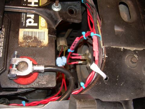 1984 Ford Bronco - Close-up of a vehicle battery and its wiring, likely for a headlight rewire project.