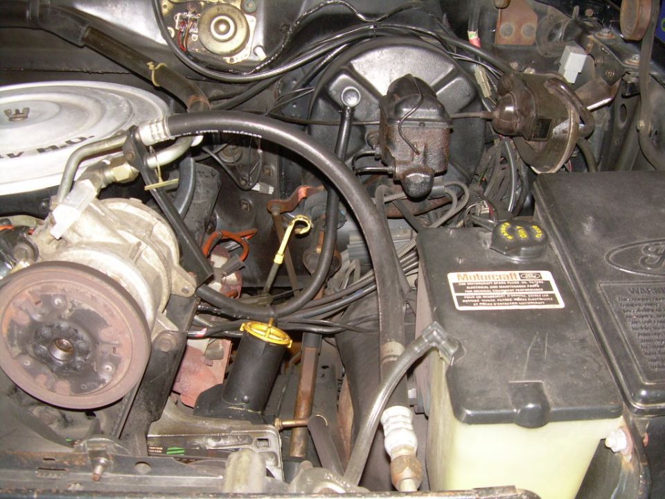 Engine bay with various hoses, wires, and a master cylinder. A "Multigard 250" sticker is visible on a black plastic component