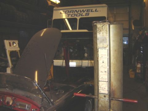 1992 Ford Bronco - A car is parked in a garage with its hood open, next to a lift and a Cornwell Tools truck.