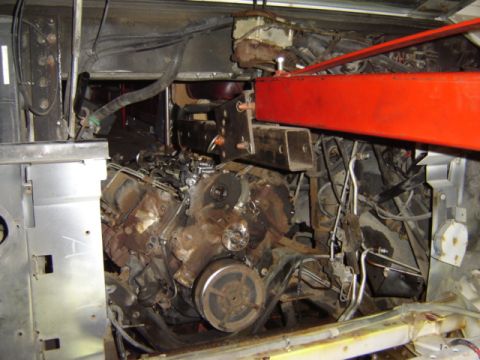 1992 Ford Bronco - The engine bay is filled with complex machinery and a prominent red beam overhead.